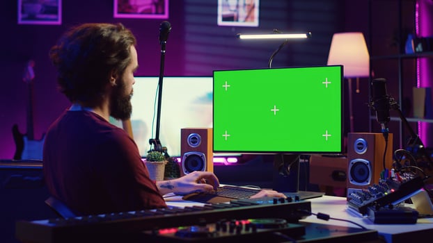 Sound engineer beginner learning acoustical engineering and mastering for music industry post production. Artist watches tutorial on greenscreen pc to use mixing console and equalizer. Camera A. photo