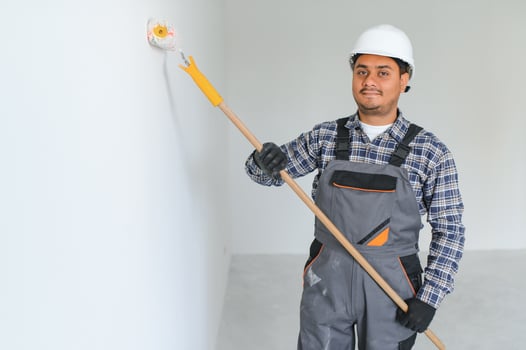 Indian worker makes repairs in an apartment photo