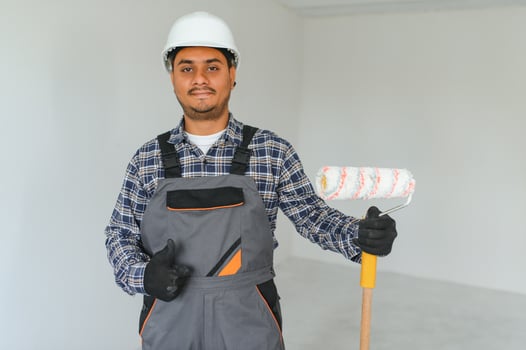 Indian worker makes repairs in an apartment photo