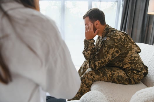 Sad male soldier on appointment with psychologist at office photo