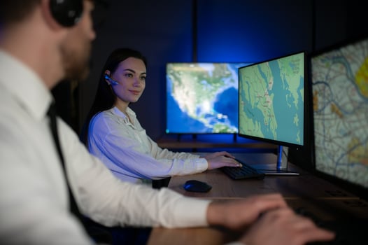 Center of dispatching maintenance. Portrait of cheerful woman and man working via headset microphone while sitting on navigation controller board photo