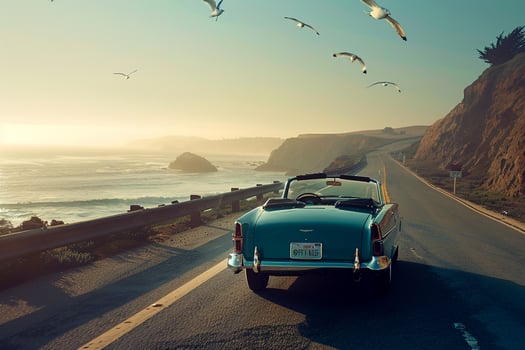 Freedom Convertible driving along scenic coastal road with cliffs overlooking the ocean and seagulls flying overhead background photo
