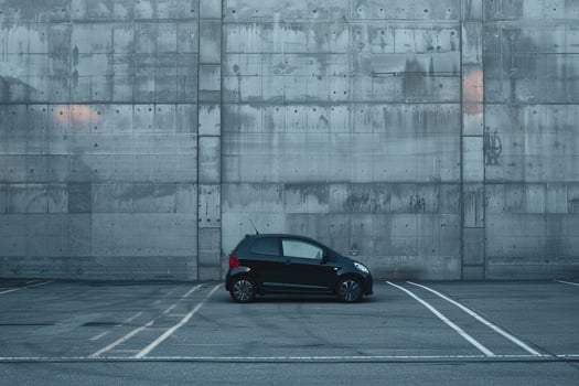 Urban Subcompact hatchback parked in minimalist urban parking lot with concrete walls and  ambient lighting photo