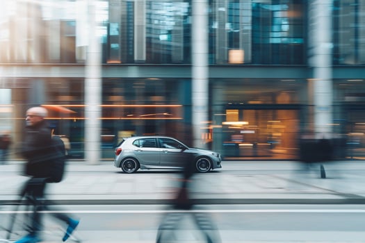 Urban Compact hybrid car driving through city street lined with contemporary architecture and pedestrians photo
