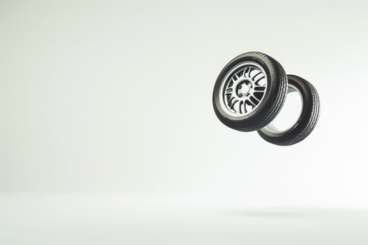 Car wheels levitating against blank white background creating floating effect photo