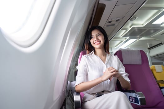 Businesswoman Smiling While Traveling on an Airplane for a Business Trip, Seated in Comfortable Business Class photo