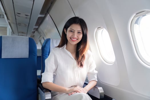 Professional Businesswoman Traveling on an Airplane, Smiling and Confident in a Modern Business Class Cabin photo