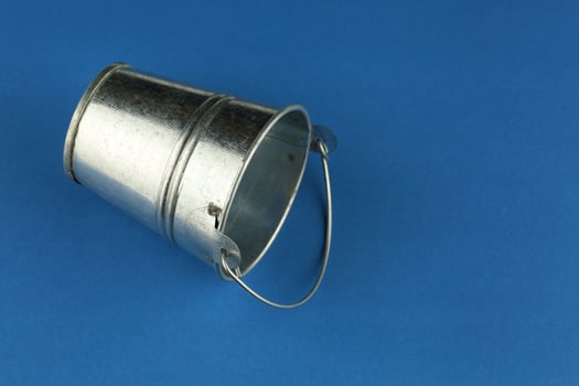 Empty metal bucket on a blue background photo