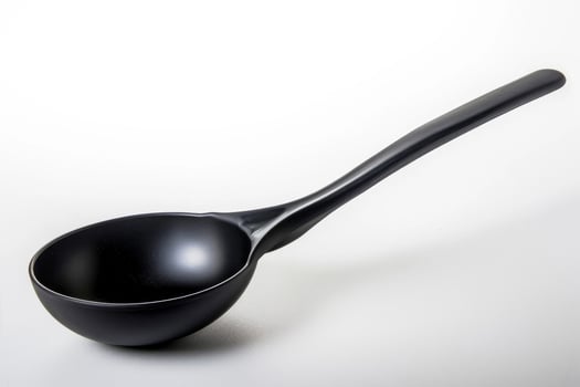 Black plastic soup ladle on a white background. photo