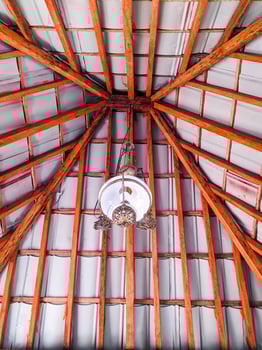 Joglo is the name of a traditional Javanese house. The interior of the Joglo roof is teak wood with antique glass lamps. hanging decorative lights in a Javanese-style hall photo