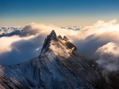 mountain peak looks out of the clouds photo
