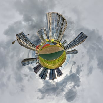 abstract swirling tiny planet spherical panorama of multi-storey buildings of skyscrapers of a residential complex in the form of a butterfly, bugs, crabs in blue sky photo