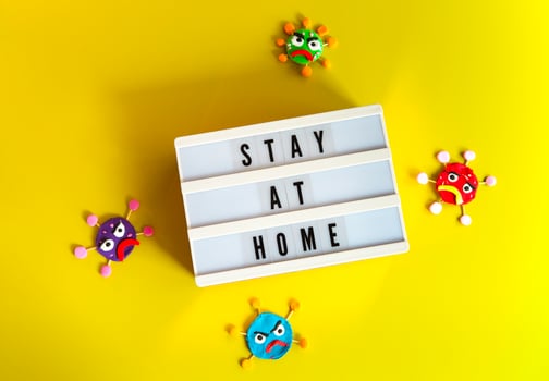 Clay characters on yellow background and board with Stay At Home writing photo