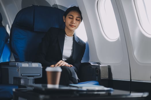 Tired young asian businesswoman eyes closed taking a nap at her seat during a flight on airplane. Transportation and business people concept. photo