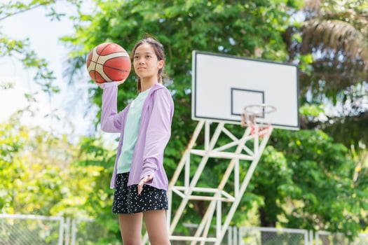 Active Asian kid girl playing basketball in the urban outdoor basketball court, Healthy life concepts photo