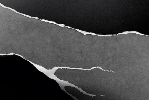 Torn Black Paper on Gray Background photo