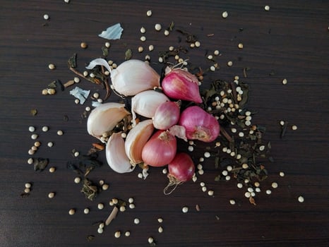 shallots and garlic sprinkled with coriander and dried tea leaves photo