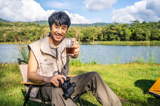 Young asian man relax travel nature in the holiday, camping and drinking coffee after boiling water, he camping on holiday. photo