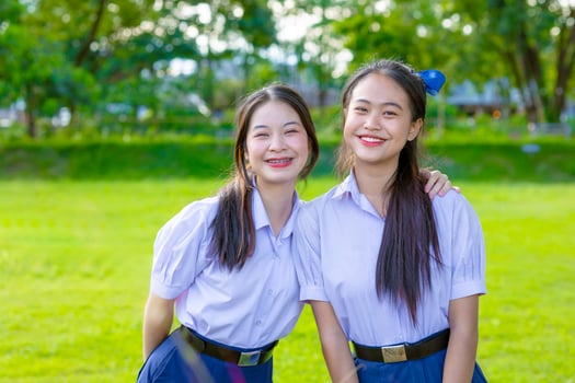 Portrait two happy smile Asian school teen girls friend in uniform at green park outdoor together photo