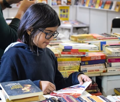 Delhi, India, July 17 2024 - Various age group people reading variety of Books on shelf inside a book-stall at Delhi International Book Fair, Books in Annual Book Fair at Bharat Mandapam complex photo