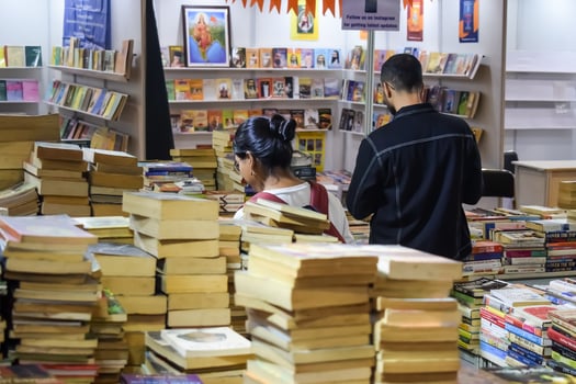 Delhi, India, July 17 2024 - Various age group people reading variety of Books on shelf inside a book-stall at Delhi International Book Fair, Books in Annual Book Fair at Bharat Mandapam complex photo