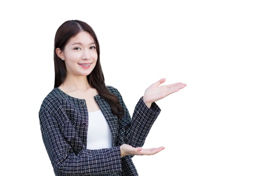 Asian professional working woman who wears black suit with braces on teeth is pointing hand to present something while isolated white background. photo