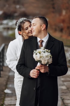 A man and a woman are hugging each other, the man is holding a bouquet of flowers photo