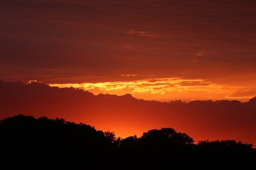 Golden sunset, dark clouds in sunrise time. Beautiful light of nature. Amazing red colors of the setting sun. Majestic clouds flowing in sunrise sky. Evening dark clouds photo