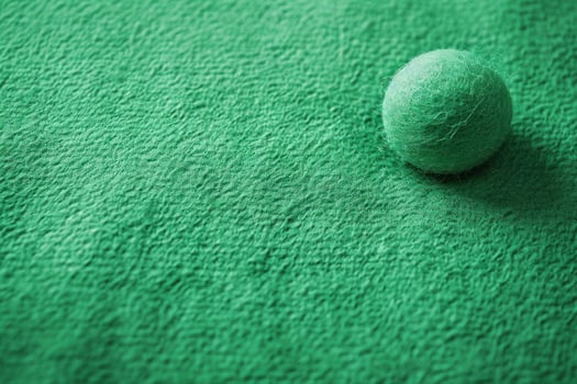 the ball is lying on the green carpet, photo