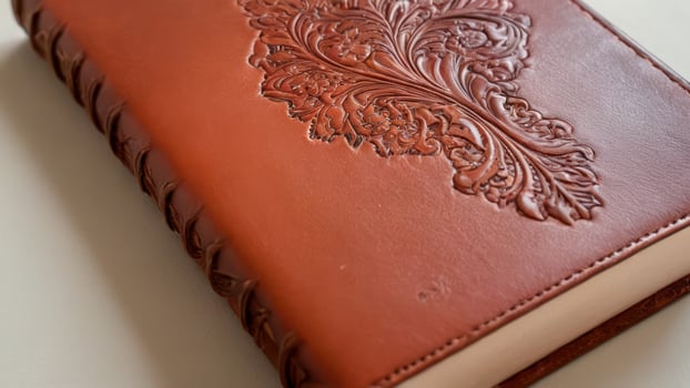a leather journal style book covered in intricate design, photo