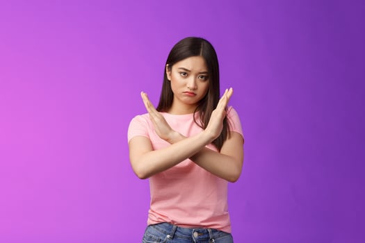Serious-looking annoyed fed up asian girl demand stop, make arm cross chest forbidden gesture, look with scorn and disappointment, refusing terrible offer, give rejection, wanna end argument photo
