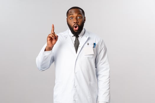 Covid19, healthcare and clinic concept. African american male doctor, physician have great idea, raise finger up eureka sign, gasping, saying his suggestion, explain plan or usage of medical masks photo