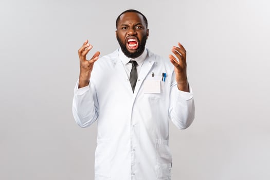 Angry, hateful african-american male doctor pissed-off people dont follow prescriptions, walking outdoors during covid19 quarantine, panemic outbreak, shaking hands and scream outraged photo