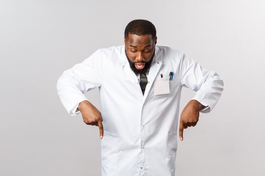 Healthcare, insurance and clinic concept. Impressed, excited happy african-american doctor seeing great deal, special offer discount on pharmacy online page, pointing fingers and looking down photo