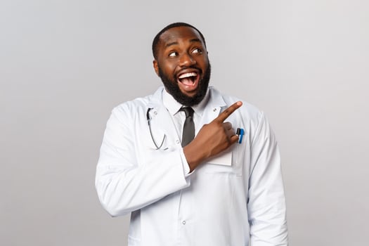 Healthcare, medicine and epidemic concept. Excited, happy and amused smiling african-american doctor pleased with new product in pharmacy store, pointing finger right, recommend this pills photo