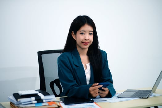 Attractive asian woman using a laptop PC and a smart phone. photo