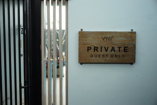 The wooden signboard with the words Private Guest Only hanging on the white wall photo