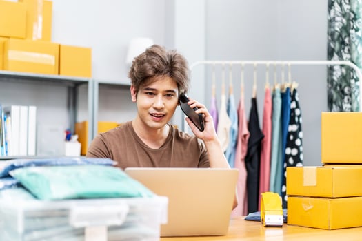 Startup small business entrepreneur SME, asian man receive order on phone. Portrait young Asian small business owner home office, packing boxes, SME sellers, e-commerce team, online sales photo