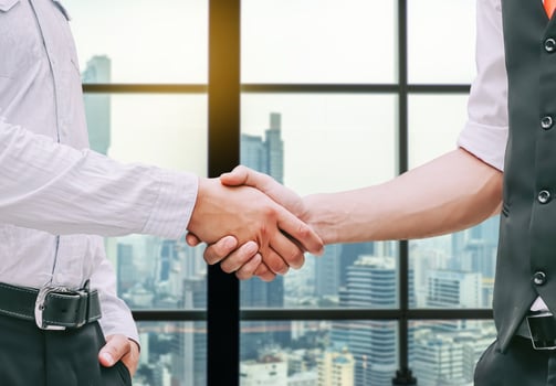 Close up of a business hand shake between two colleagues - greeting, dealing, merger and acquisition concepts on Modern glass building background photo
