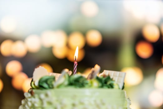 Happy birthday cake with candles on the background of bright lights bokeh. photo