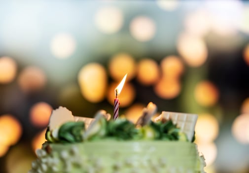 Happy birthday cake with candles on the background of bright lights bokeh. photo