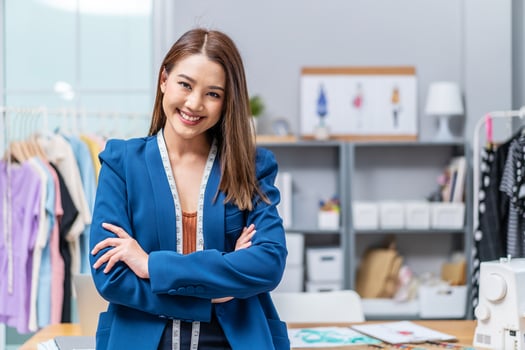 Beautiful asian woman business owner, Fashion designer with tape measure working in fashion sitting on desk, Concept Professional Dressmaker designer photo