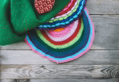 Knitted mat and covers on wooden background photo