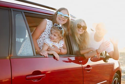 Happy smiling family with daughters in the car with sea background photo