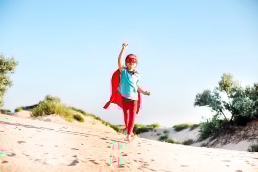 Portrait of Superhero kid against blue sky background photo