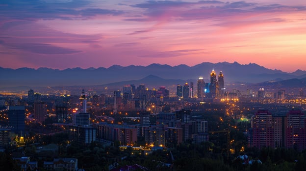 An expansive view of Almaty's cityscape at dusk with vibrant lights and mountains visible. photo