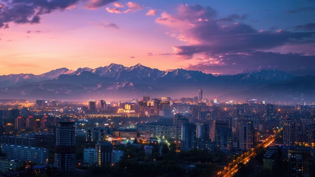 An expansive view of Almaty's cityscape at dusk with vibrant lights and mountains visible. photo