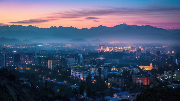 An expansive view of Almaty's cityscape at dusk with vibrant lights and mountains visible. photo