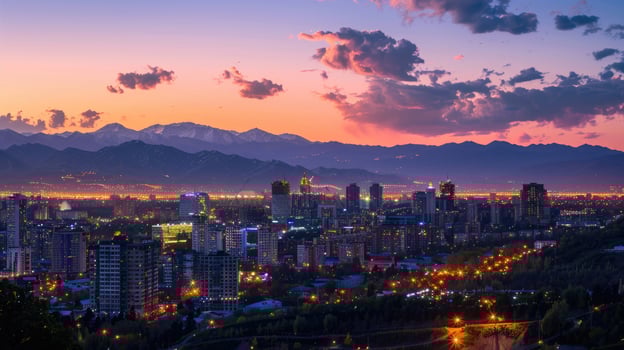 An expansive view of Almaty's cityscape at dusk with vibrant lights and mountains visible. photo
