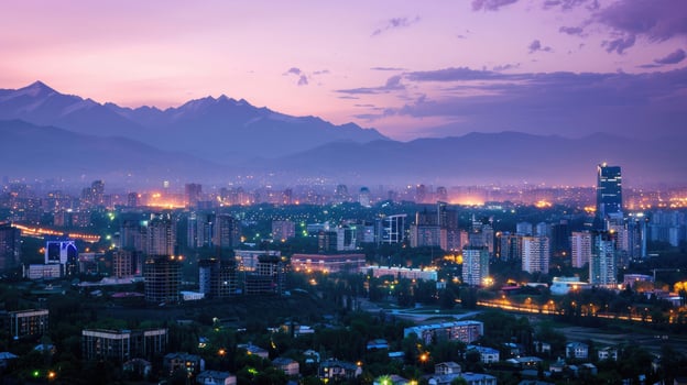 An expansive view of Almaty's cityscape at dusk with vibrant lights and mountains visible. photo